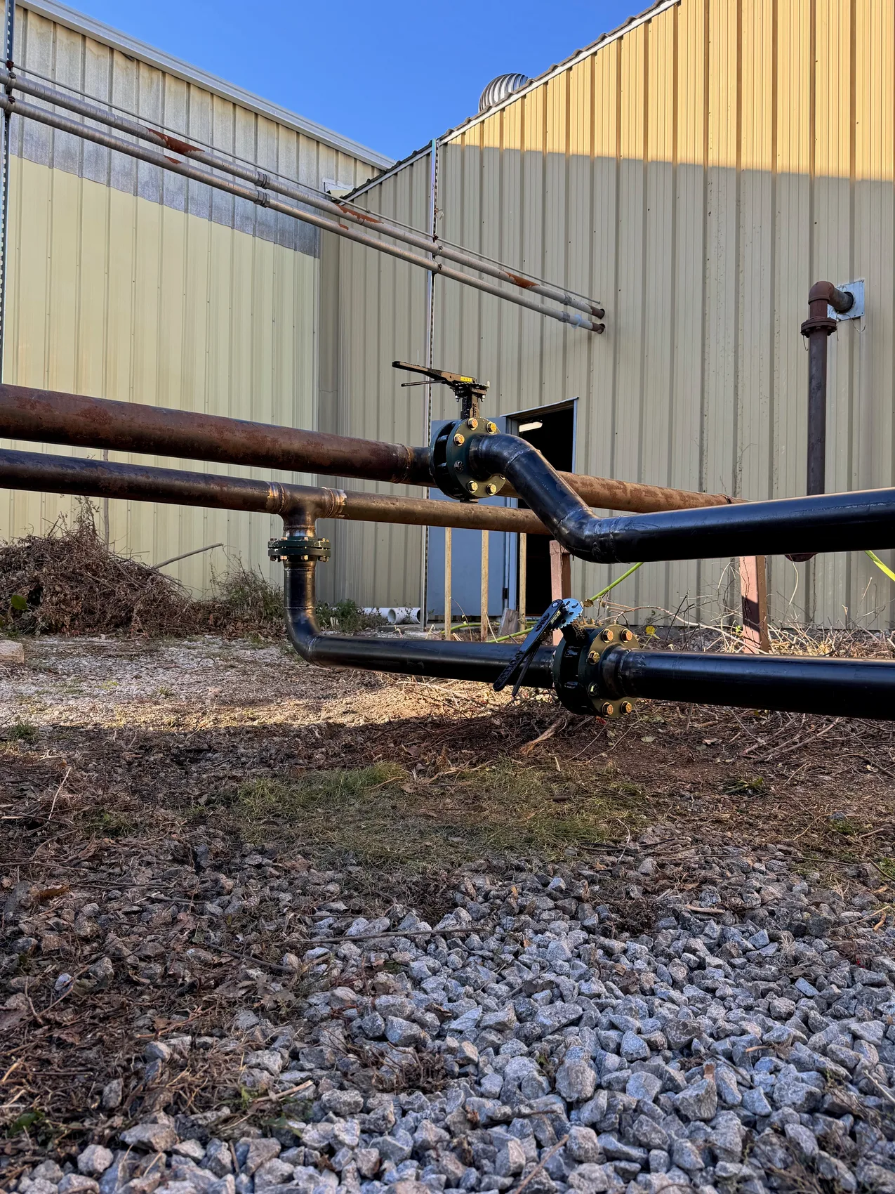 Welded black-iron chiller piping along the building