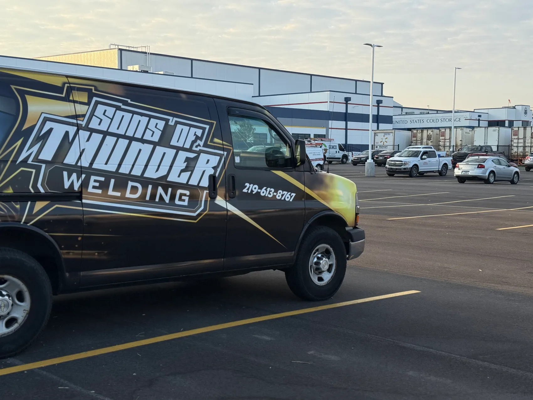 Sons of Thunder Welding wrapped van at a commercial facility